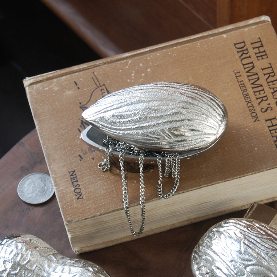 Textured silver almond dish displayed on wooden surface