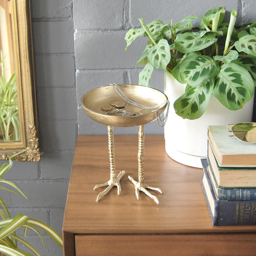 Unique gold bird-leg bowl used as a home décor accent indoors