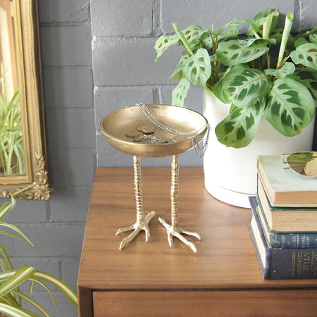 Unique gold bird-leg bowl used as a home décor accent indoors