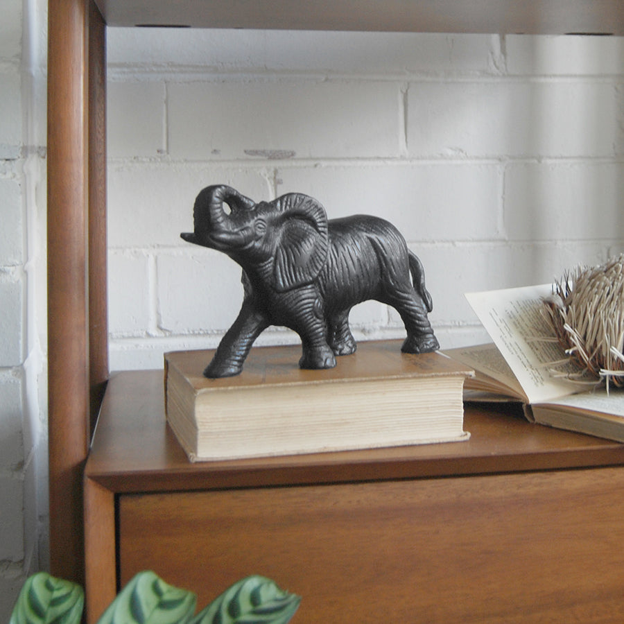 Black elephant ornament with raised trunk indoors
