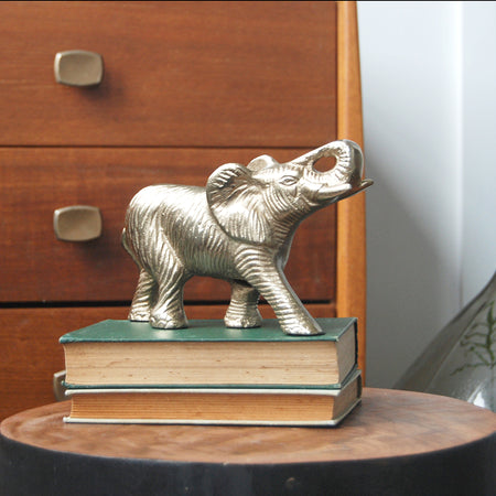 Textured gold elephant ornament on wooden console