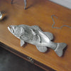 Silver fish dish sculpture holding jewellery and keys on wooden surface