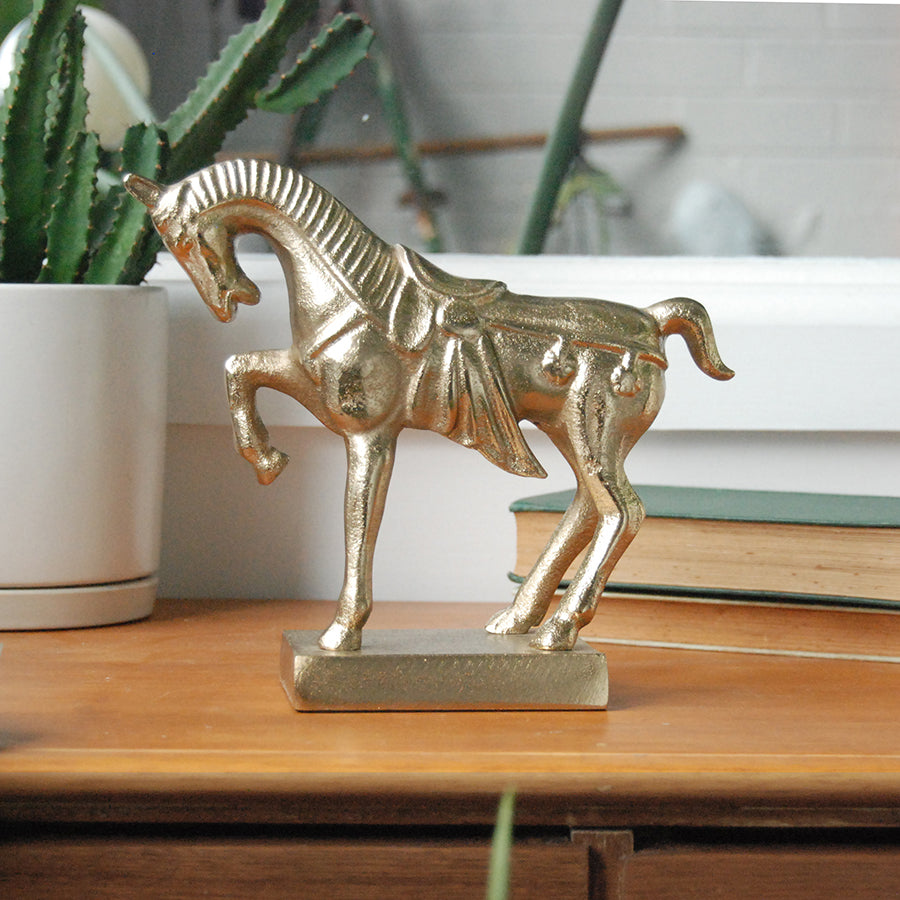 Metallic gold equine figurine styled indoors
