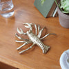 Metallic gold lobster ornament displayed as wall décor