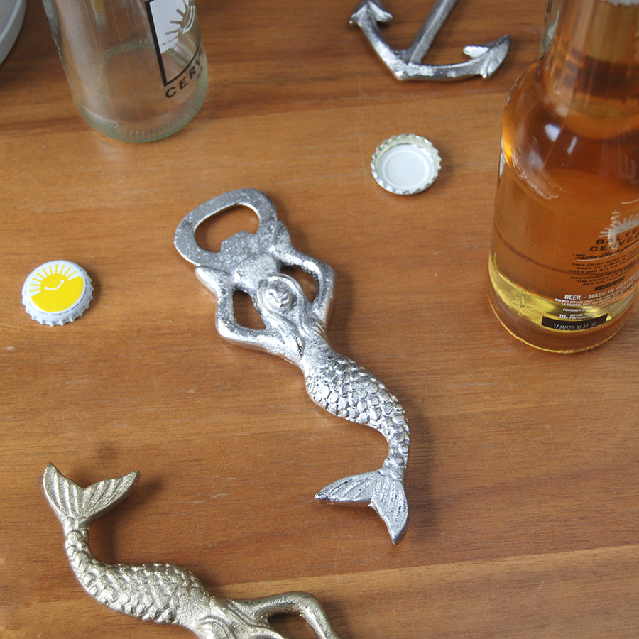Metal mermaid-shaped bottle opener styled with drinks
