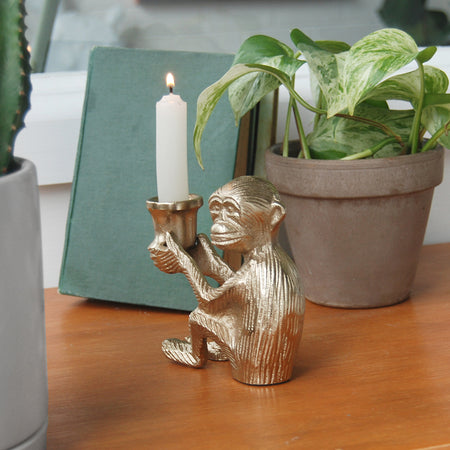 Sculptural gold candle holder in the shape of a seated monkey