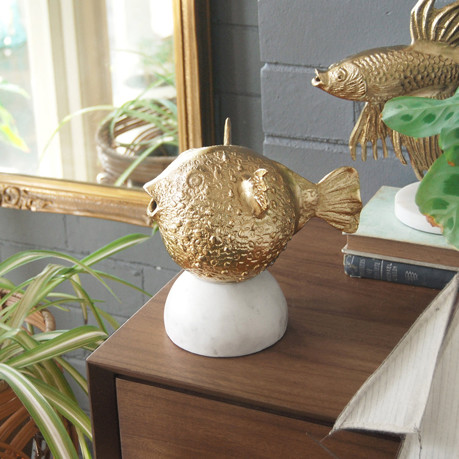 Quirky gold home décor piece featuring pufferfish design