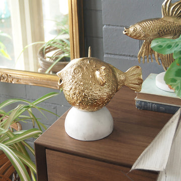 Quirky gold home décor piece featuring pufferfish design