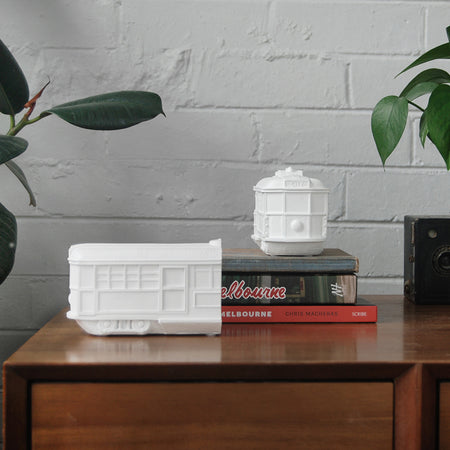 White resin Melbourne tram bookends styled on timber cabinet with books