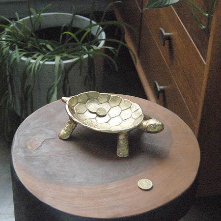 Sculptural gold turtle bowl displayed on timber surface