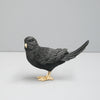 Decorative Black budgie styled against a soft grey background