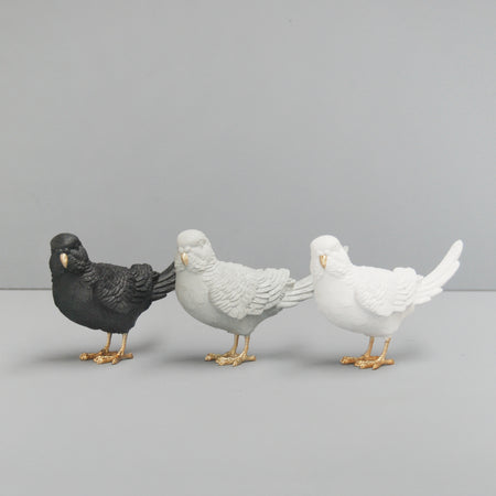 Set of three resin budgie sculptures in black, grey, and white with gold accents