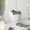 Modern white resin plant pot on round table with festive ornaments