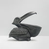 Black pelican sculpture with open beak storage used as functional decor