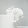 Decorative bunny figure positioned on a white and timber side table
