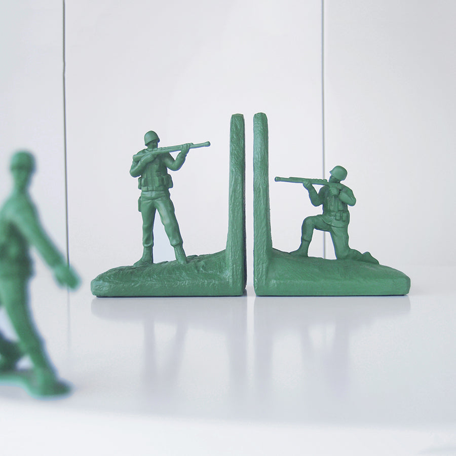 Green army soldier bookends by White Moose styled on white bookshelf